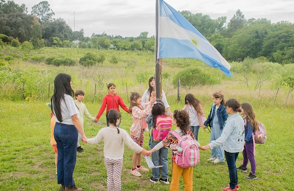Niños alrededor de la bandera en La Colmena